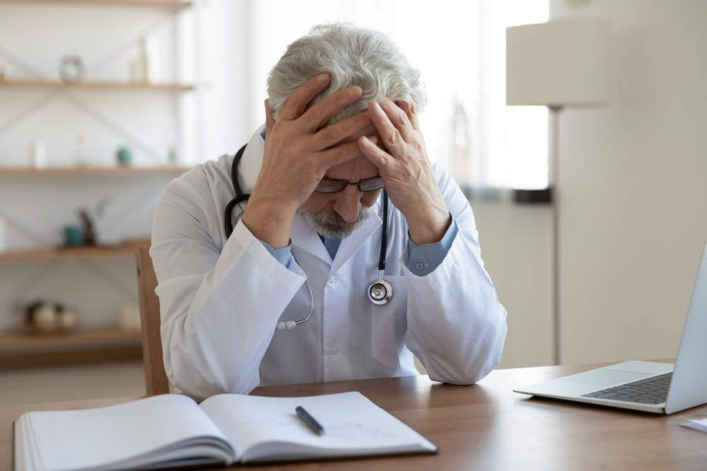 tired depressed old male doctor feels desperate thinking of medical problem feels burnout at work