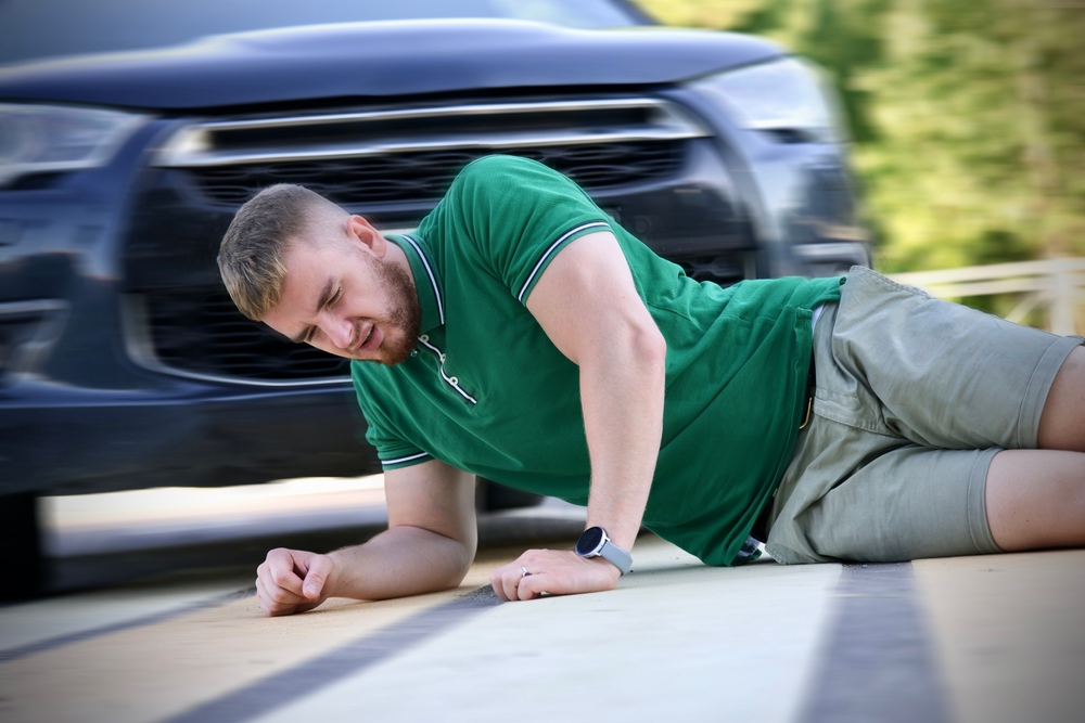 pedestrian guy hit by careless driver in a car on the road while crossing highway