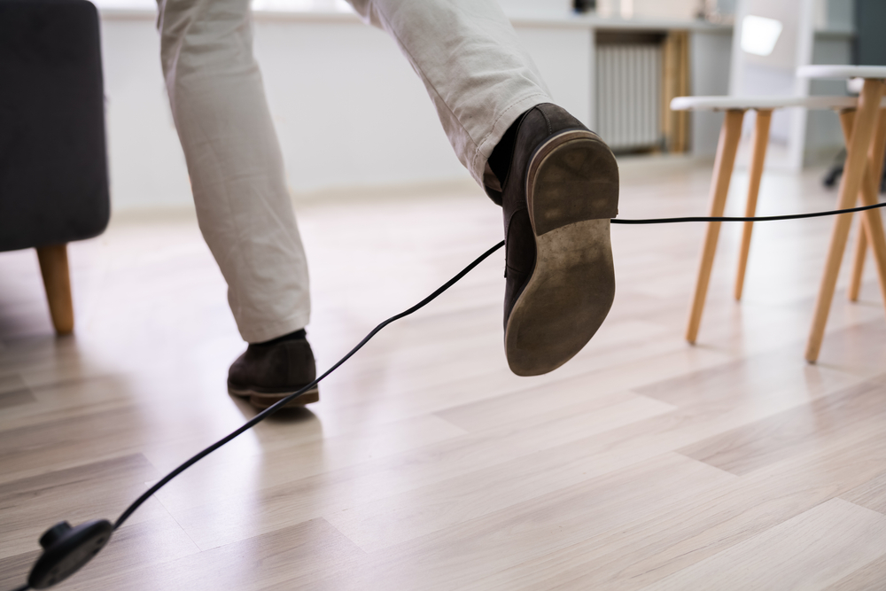 a man legs stumbling with an electrical cord at home