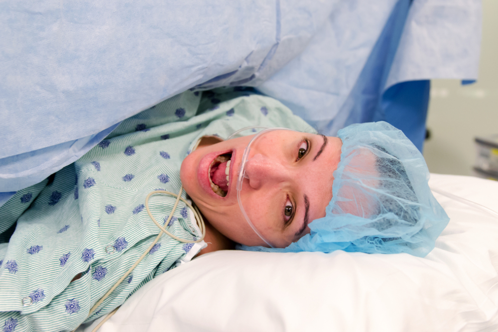 a woman is on an operating table during surgery with a horrified screaming expression