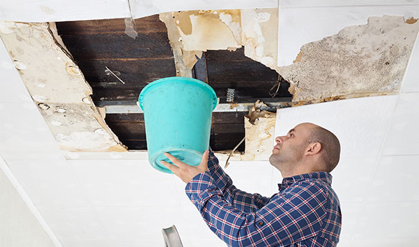 man fixing the collapsed ceiling